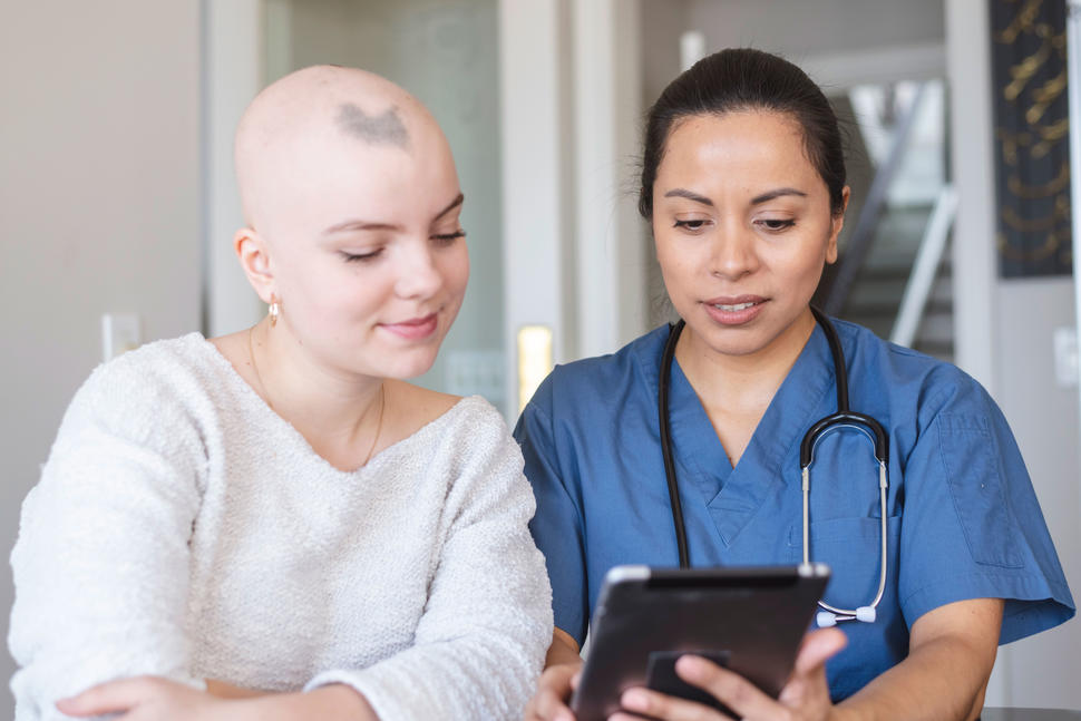 Una jóven con cáncer habla con su enfermera.