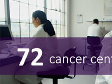 three people in lab coats, sitting at desks, with 72 cancer centers banner on image.