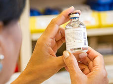Pharmacist examining a drug vial.