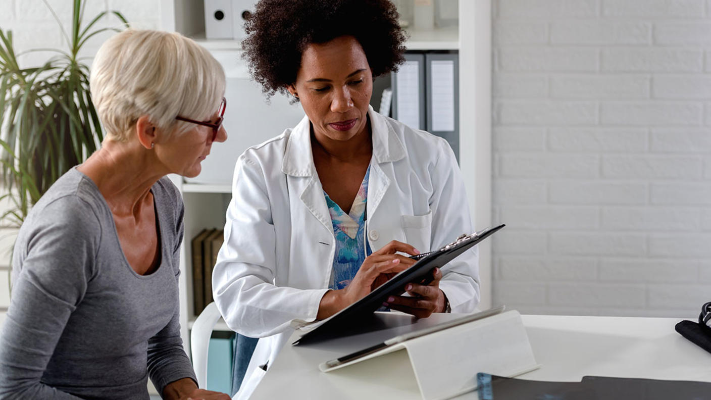 Female doctor and female patient review medical chart together