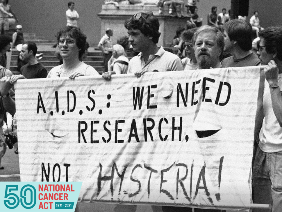 People holding a banner and marching for AIDS research. 