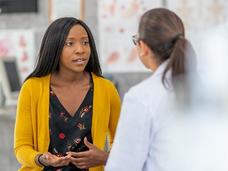 A young black woman speaking with her doctor